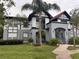 Two-story condo building with gray and white exterior, landscaping, and palm trees at 5525 Pga Blvd # 4614, Orlando, FL 32839