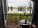 Relaxing back patio with lake view, small table, and metal railing at 5525 Pga Blvd # 4614, Orlando, FL 32839