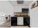 Modern galley kitchen with granite countertops and stainless steel appliances at 6165 Carrier Dr # 1214, Orlando, FL 32819