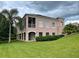 Two-story house with balcony, lush landscaping, and a large backyard at 633 Copeland Dr, Haines City, FL 33844