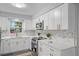 Modern kitchen with white cabinets, stainless steel appliances, and marble backsplash at 274 N Ranger Blvd, Winter Park, FL 32792