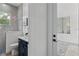 Bathroom with shower, toilet and vanity, plus a view into a sunroom at 3429 Boggy Creek Rd, Kissimmee, FL 34744