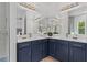 Bathroom with a corner double vanity and blue cabinets at 3429 Boggy Creek Rd, Kissimmee, FL 34744
