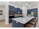 Modern kitchen with island, stainless steel appliances, and dark blue cabinetry at 3429 Boggy Creek Rd, Kissimmee, FL 34744