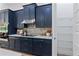 Kitchen with dark blue cabinetry, stainless steel appliances, and a walk-in pantry at 3429 Boggy Creek Rd, Kissimmee, FL 34744