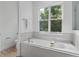 Relaxing bathroom featuring a soaking tub and large window at 3429 Boggy Creek Rd, Kissimmee, FL 34744