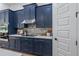 Kitchen with dark blue cabinetry, stainless steel appliances, and a walk-in pantry at 3429 Boggy Creek Rd, Kissimmee, FL 34744