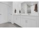 Bright bathroom boasts double sinks, a large mirror, and modern white cabinets at 2658 Mandevilla Ct, Clermont, FL 34711