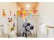 Bathroom with a colorful shower curtain and Mickey Mouse decor at 17317 Hidden Forest Dr, Clermont, FL 34714