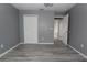 Well-lit bedroom featuring grey walls, wood-look floors, and ample closet space at 106 Cheltenham Pl, Kissimmee, FL 34758