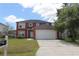 Two-story red house with attached garage at 106 Cheltenham Pl, Kissimmee, FL 34758