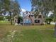 Back view of renovated home with patio and landscaping at 1689 Lakeshore Dr, Eustis, FL 32726