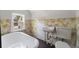 Vintage bathroom with clawfoot tub and fern wallpaper at 1689 Lakeshore Dr, Eustis, FL 32726