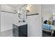 Modern bathroom with dark vanity, white tile, and polka dot floor at 1689 Lakeshore Dr, Eustis, FL 32726