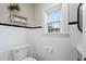 Clean bathroom with white tile, pedestal sink, and a classic toilet at 1689 Lakeshore Dr, Eustis, FL 32726