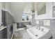 Clean bathroom with gray tile, white bathtub, and pedestal sink at 1689 Lakeshore Dr, Eustis, FL 32726