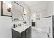 Stylish bathroom with dark vanity, white fixtures, and black and white tile floor at 1689 Lakeshore Dr, Eustis, FL 32726