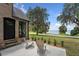 Brick patio with lake view, two chairs, and manicured landscaping at 1689 Lakeshore Dr, Eustis, FL 32726