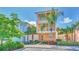 Two-story house with orange exterior, green accents, and palm trees at 8016 Flip Flop Way, Kissimmee, FL 34747