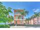 Two-story house with orange exterior, green accents, and palm trees at 8016 Flip Flop Way, Kissimmee, FL 34747