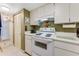 White kitchen cabinets and appliances, with tiled floors at 3801 S Atlantic Ave # 321, New Smyrna Beach, FL 32169
