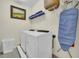 Laundry room with washer, dryer, shelving, and ironing board at 7706 Graben St, Kissimmee, FL 34747