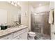 Bathroom with granite countertop, shower, and white cabinets at 7143 Oakmoss Loop, Davenport, FL 33837