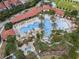 Aerial view of resort-style pool with multiple areas, palm trees, and a waterslide at 7143 Oakmoss Loop, Davenport, FL 33837