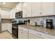 Modern kitchen with white cabinets, granite countertops and stainless steel appliances at 7143 Oakmoss Loop, Davenport, FL 33837