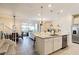 Open concept kitchen with island and view into the dining and living areas at 7143 Oakmoss Loop, Davenport, FL 33837
