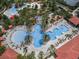 Aerial view of community pool area with multiple pools, a lazy river, and a waterslide at 7143 Oakmoss Loop, Davenport, FL 33837