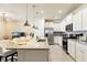Modern kitchen with white cabinets, granite countertops, and stainless steel appliances at 7143 Oakmoss Loop, Davenport, FL 33837
