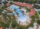 Aerial view of a large community pool with lounge chairs and palm trees at 7143 Oakmoss Loop, Davenport, FL 33837