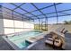 Private screened-in pool with lake view and patio furniture at 7143 Oakmoss Loop, Davenport, FL 33837