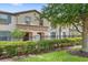 Townhouse exterior with a well-maintained lawn and iron fence at 2015 Majorca Drive, Kissimmee, FL 34747