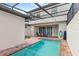 Private screened-in pool with brick pavers and lounge chairs at 2015 Majorca Drive, Kissimmee, FL 34747