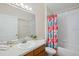 Clean bathroom with shower/tub combo and colorful shower curtain at 619 Cheshire Way, Davenport, FL 33897