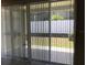 View of backyard through sliding glass doors with vertical blinds at 8073 Cherrystone St, Leesburg, FL 34748