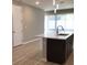 Modern kitchen island with white countertops and dark brown cabinets at 8073 Cherrystone St, Leesburg, FL 34748