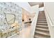 Bright entryway with stairs leading upstairs and view into the kitchen at 7252 Oakmoss Loop, Davenport, FL 33837