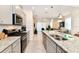 Modern kitchen features granite countertops, stainless steel appliances, and breakfast bar at 7252 Oakmoss Loop, Davenport, FL 33837