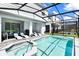 Private pool and spa with screened enclosure and outdoor seating at 7252 Oakmoss Loop, Davenport, FL 33837