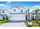 Two story home with white exterior, two car garage and landscaping at 7252 Oakmoss Loop, Davenport, FL 33837