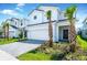 Two story home with white exterior, two car garage and landscaping at 7252 Oakmoss Loop, Davenport, FL 33837