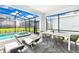 Covered patio with dining area and lounge chairs adjacent to the pool at 7252 Oakmoss Loop, Davenport, FL 33837