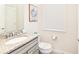 Small bathroom with granite countertop, toilet and pedestal sink at 7252 Oakmoss Loop, Davenport, FL 33837