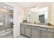 Elegant bathroom with double vanity and a large walk-in shower at 7252 Oakmoss Loop, Davenport, FL 33837