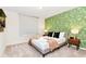 Bedroom with queen-size bed and nature-inspired wallpaper at 7252 Oakmoss Loop, Davenport, FL 33837