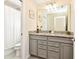 Bathroom with double vanity, granite countertop, and shower/tub combo at 7252 Oakmoss Loop, Davenport, FL 33837