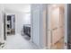 Hallway with tile flooring, linen closet, and access to bedrooms and stairs at 9076 Hazard St, Davenport, FL 33896
